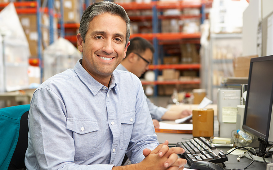 man smiling at the camera in a warehouse