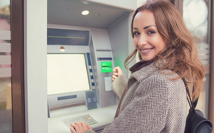 young woman checking her personal balance with an ATM