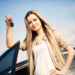 young woman holding keys to a new financed car