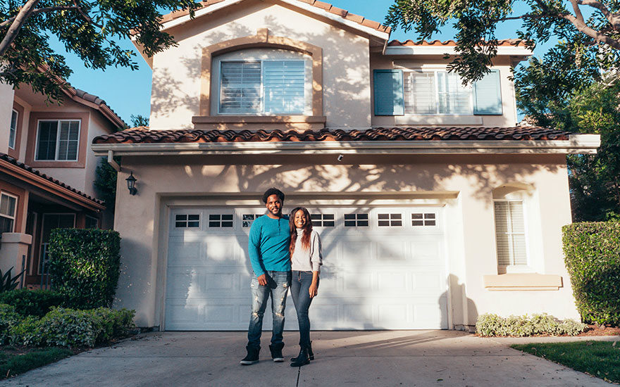 Couple in front of new home