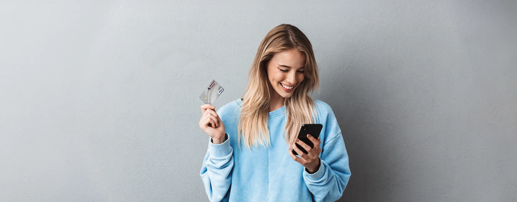 Woman holding phone and debit card
